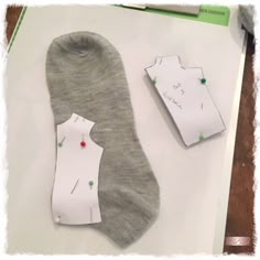 two pairs of socks are laying next to each other on a piece of white paper