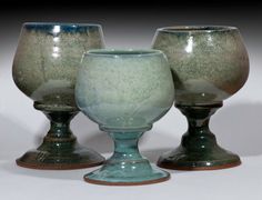 three green glass goblets sitting next to each other