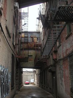 an alley way with graffiti and fire escapes