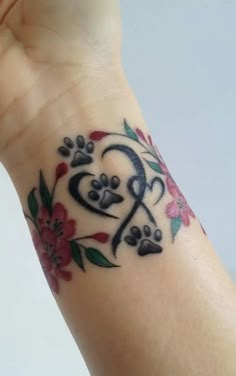 a woman's wrist tattoo with flowers and hearts