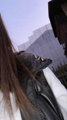 a woman with long hair wearing a leather jacket