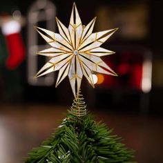 a small christmas tree with a star decoration on it's top and green needles