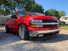 a red truck is parked in the gravel