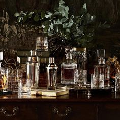 an assortment of liquor bottles and glasses on a table