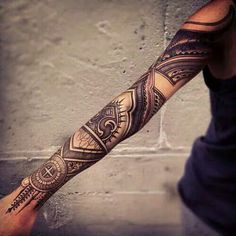 a man's arm with an intricate tattoo design on the forearm and hand,