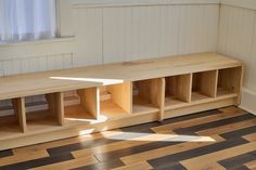 a wooden bench sitting on top of a hard wood floor