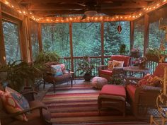 a screened porch with wicker furniture and string lights on the ceiling, surrounded by potted plants