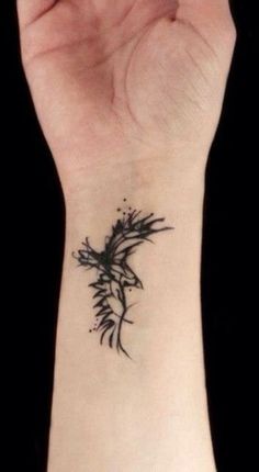 a black and white photo of a wrist tattoo with flowers on the left side of it