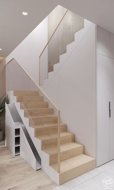 there is a stair case next to the stairs in this modern house with white walls and wood flooring