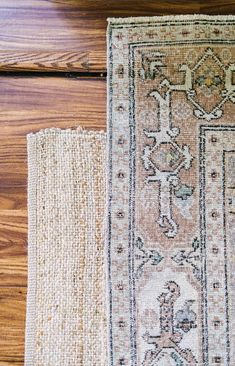 two rugs sitting on top of a wooden floor next to each other, one with an ornate design