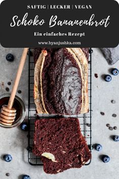 a loaf of chocolate cake sitting on top of a cooling rack next to blueberries