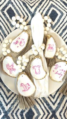 a white plate topped with cookies covered in pink and white icing next to a black and white rug