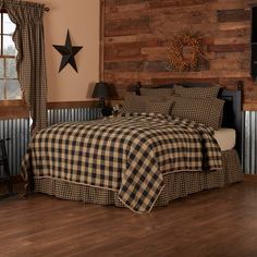 a bed in a room with wooden walls and plaid bedspread on top of it