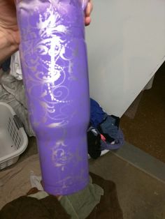 a person is holding a purple tube in their hand