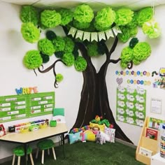 a classroom decorated in green and white with a tree on the wall