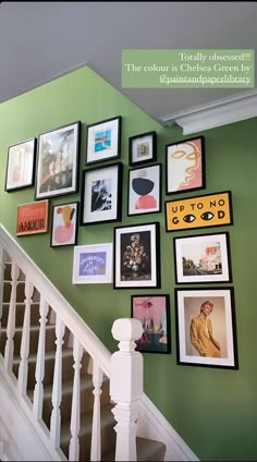 a staircase with many pictures on the wall above it and below is a handrail