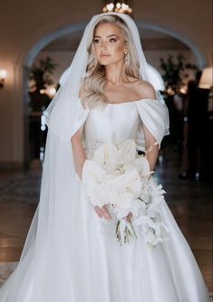 a woman in a wedding dress holding a bouquet