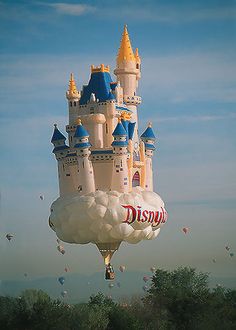 a large balloon shaped like a castle flying in the sky