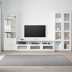 a living room with white furniture and a flat screen tv