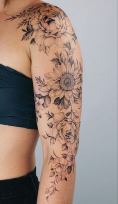 a woman's arm with flowers on it and the top half covered in black ink