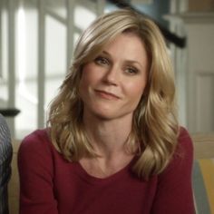 a woman sitting on top of a couch next to a man in a striped shirt