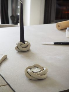 two candles sitting on top of a table next to some scissors and other crafting supplies