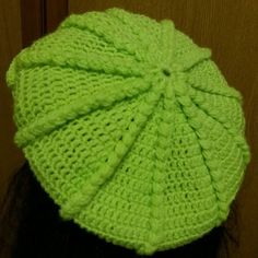 a woman wearing a green knitted hat