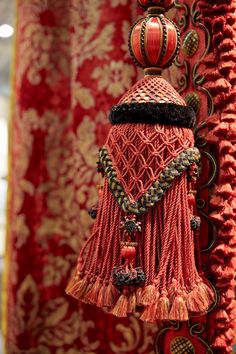 a red curtain with some tassels hanging from it's sides and other decorations on the side