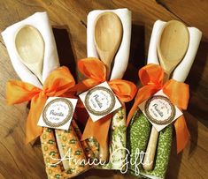 four wooden spoons with labels on them sitting next to some napkins and orange ribbons