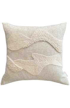 a white pillow with an embroidered design on it