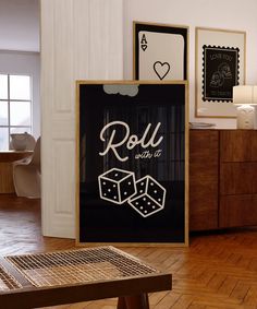 a room with wooden floors and pictures on the wall, including a sign that says roll with it