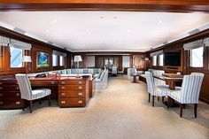 a living room filled with lots of furniture and wooden paneled walls next to windows