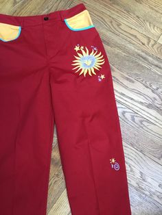 "80's happy pants in red , yellow, and blue! These pants are a bright red high waisted jean cut . The happy continues with two front inset pockets in yellow with blue trim. There are also two patch pockets in back, zipper front and button closure. The sun face and stars are depicted in yellow and blue. Just delicious fun! The fabric looks like easy care ! The only size tag says medium,but please check the measurements below!!  Measured flat. Waist,30\".                     Crotch measured to top Fun Red Bottoms For Spring, High Waisted Jean, Sun Face, Blue Trim, Red High, Yellow And Blue, Blue Accents, Bright Red, High Waist Jeans