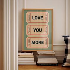 a poster with the words love you more on it next to a pile of books