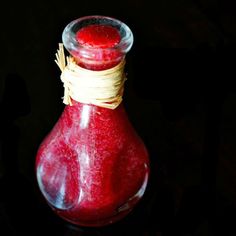 a red vase with some yellow string in it