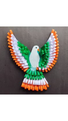 an orange, white and green bird made out of toothpicks