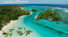 an aerial view of several small islands in the ocean with trees and water around them