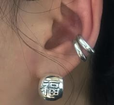 a close up of a person's ear with two silver rings on top of it