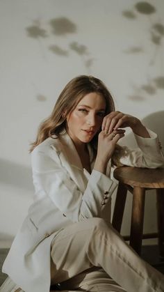 a woman sitting on top of a wooden chair