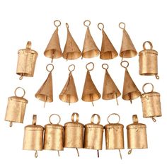 an assortment of brass bells on a white background