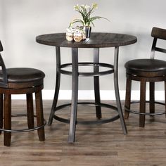 a small table with two stools and a flower pot on top of the table