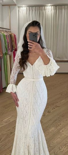 a woman is taking a selfie in her wedding dress