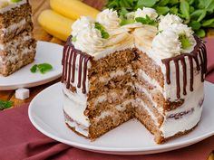 two pieces of cake sitting on top of white plates next to bananas and green leaves