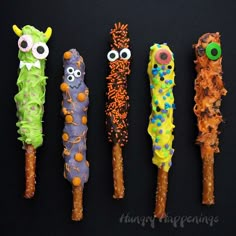 five different types of candy sticks with googly eyes and worms on them, all lined up in a row