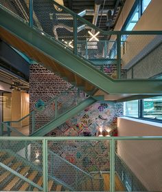 an indoor stair case with graffiti on the walls and floor, along with metal railings