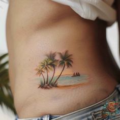 a woman's stomach with two palm trees on it