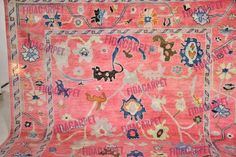 a pink rug with cats and flowers on it