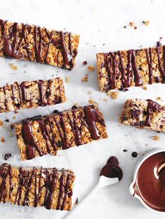 chocolate drizzled on top of granola bars next to a cup of coffee