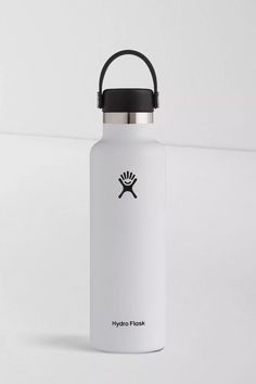 the hydro flask water bottle is white and has a black lid with a logo on it