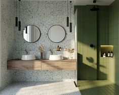 a bathroom with two sinks and mirrors on the wall next to a walk in shower